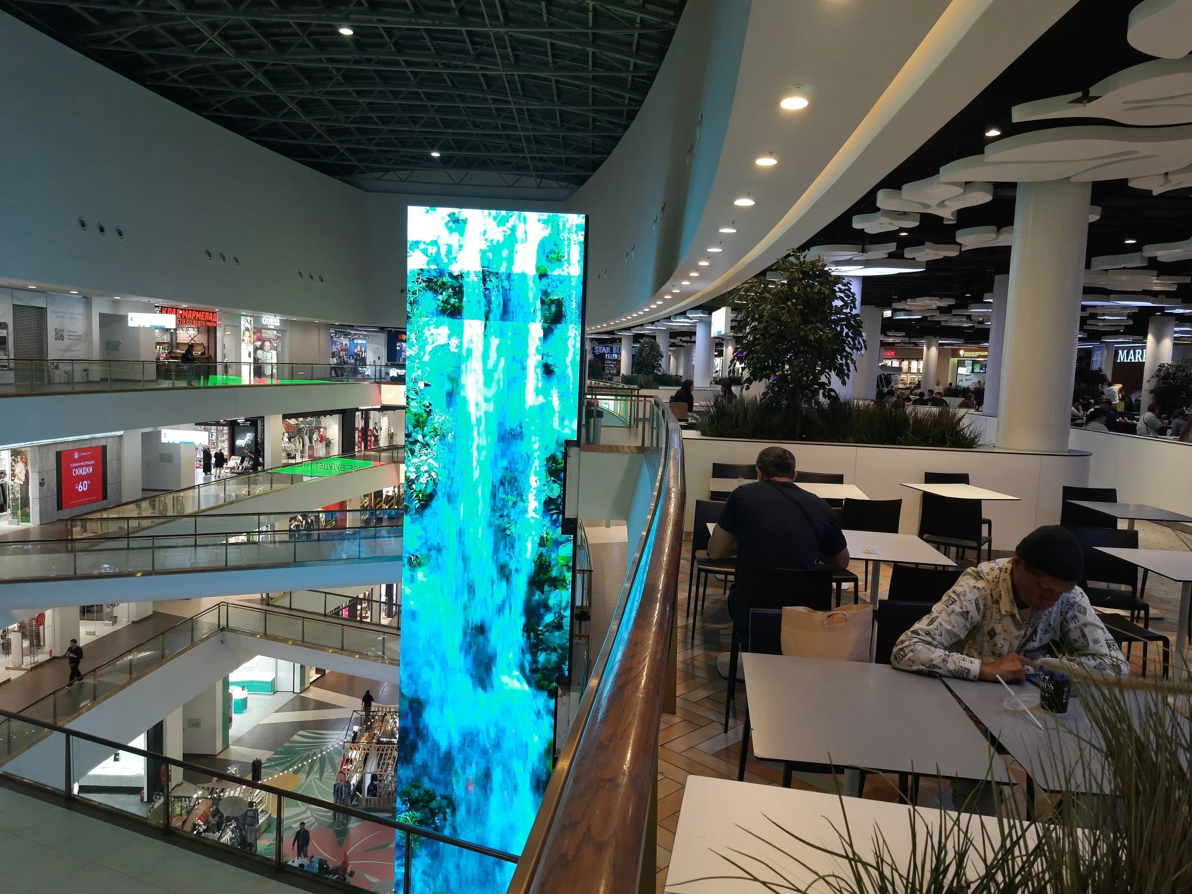 Торговая галерея в Валенсии с витринами, указателями и покупателями в выходной день