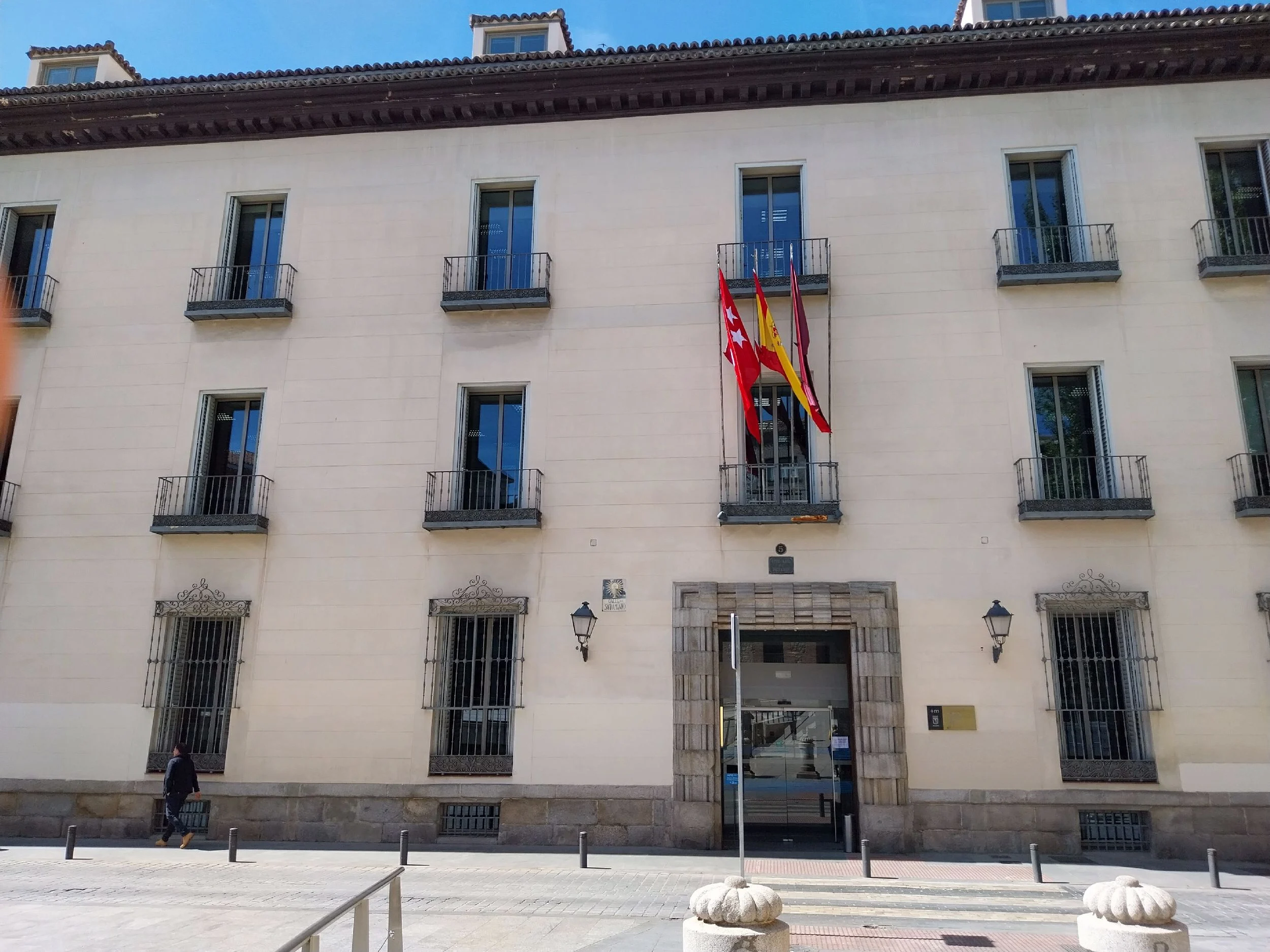 Фасад здания Agencia Tributaria на улице Calle del Sacramento в Мадриде с флагами Испании и Европейского союза