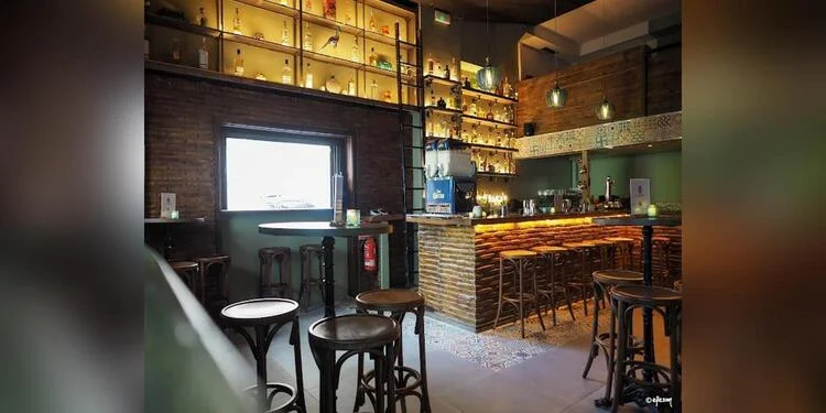 Интерьер VIBA — Drinks & Records: барная стойка с подсветкой, винтажные деревянные табуреты, полки с алкоголем и винилом
